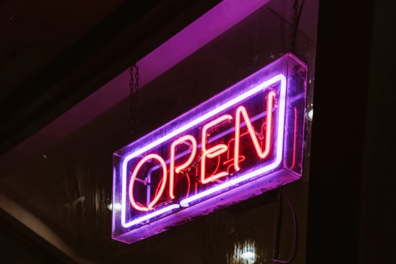 a red and purple neon sign on the side of a building