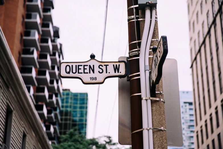 a street sign for queen st w in the city