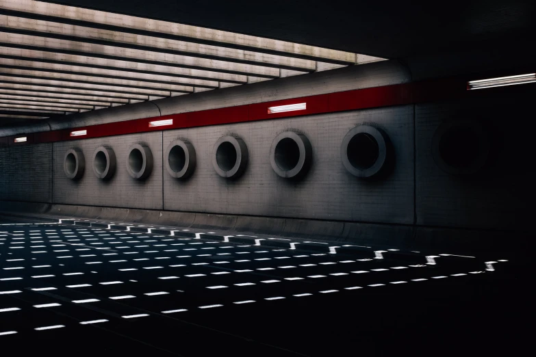 underground tunnel and rows of round windows in a dark area