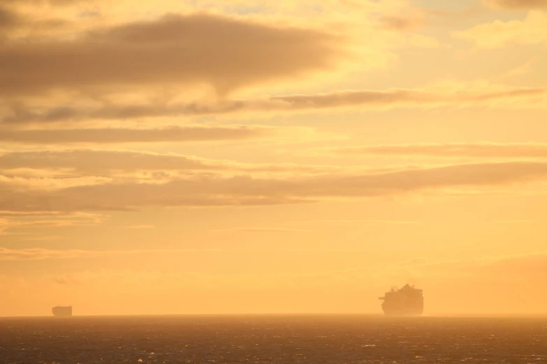 a boat traveling in the ocean at sunset