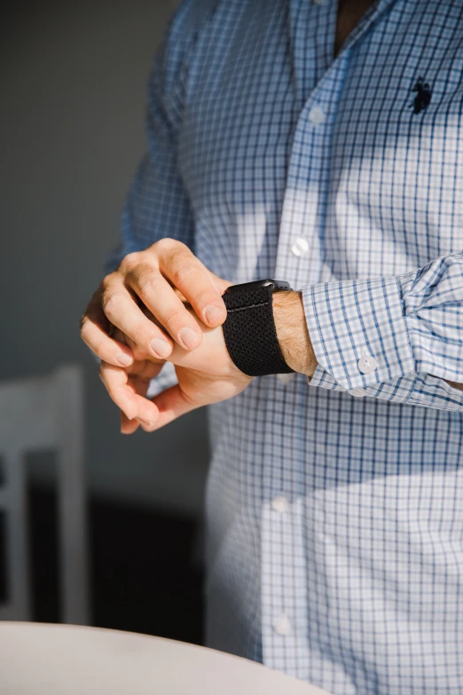 man wearing a watch holding onto his arm