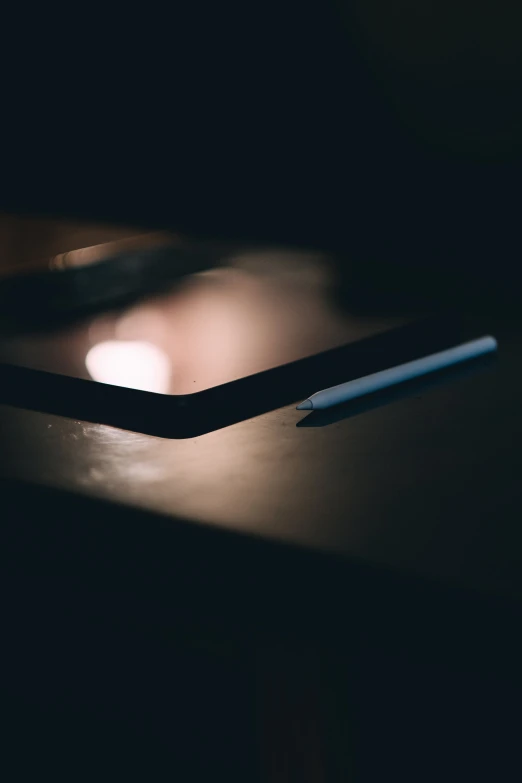 the bottom of a black desk with a pen on it