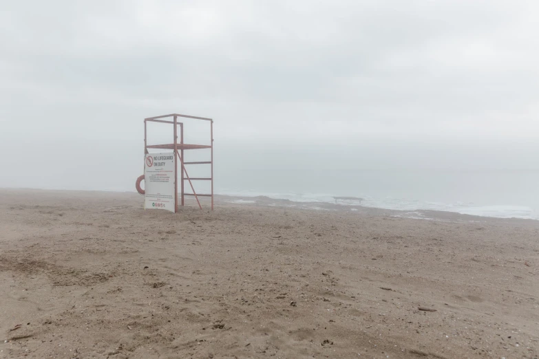 a white sign with no entry in the sand