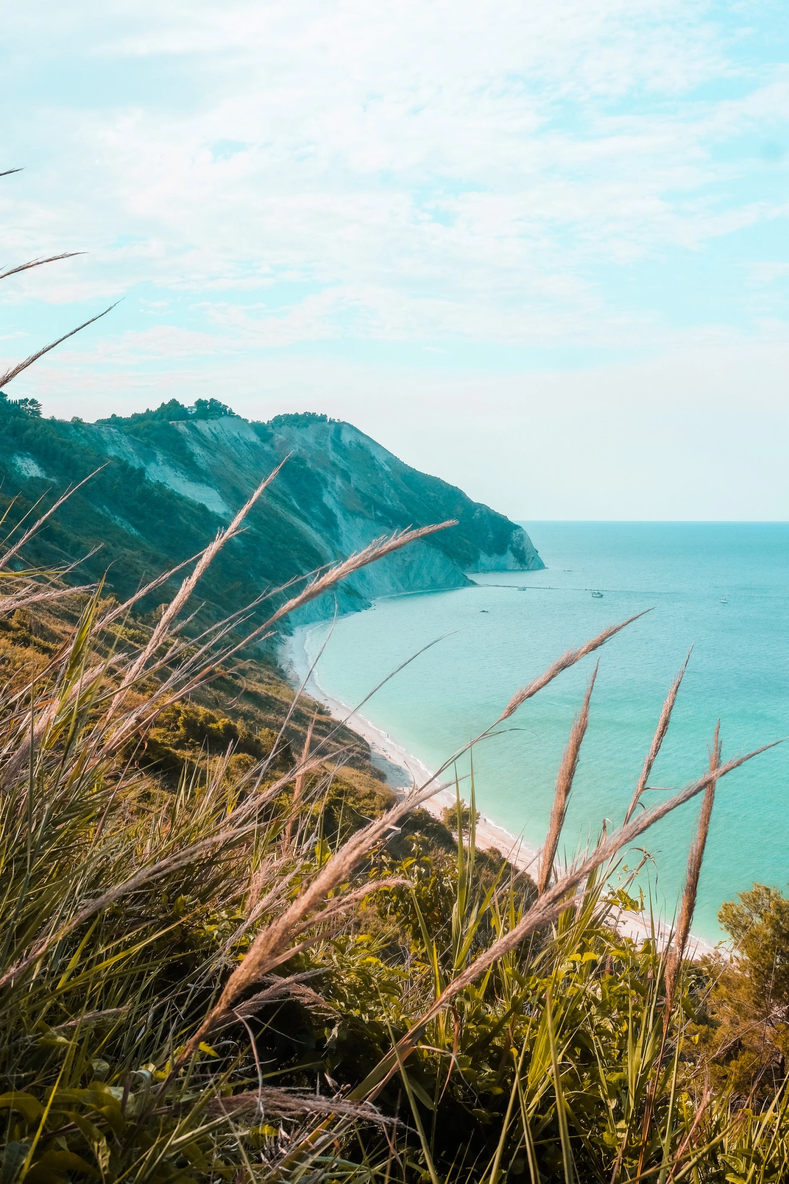 a beach next to a cliff with the ocean