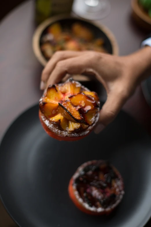 a hand placing food on top of an empty plate