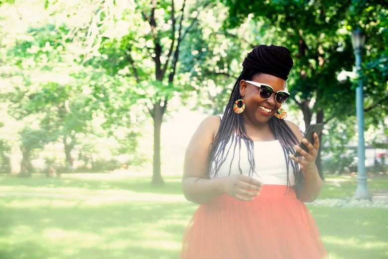 woman with long dreadlocks laughing while holding soing in her hand