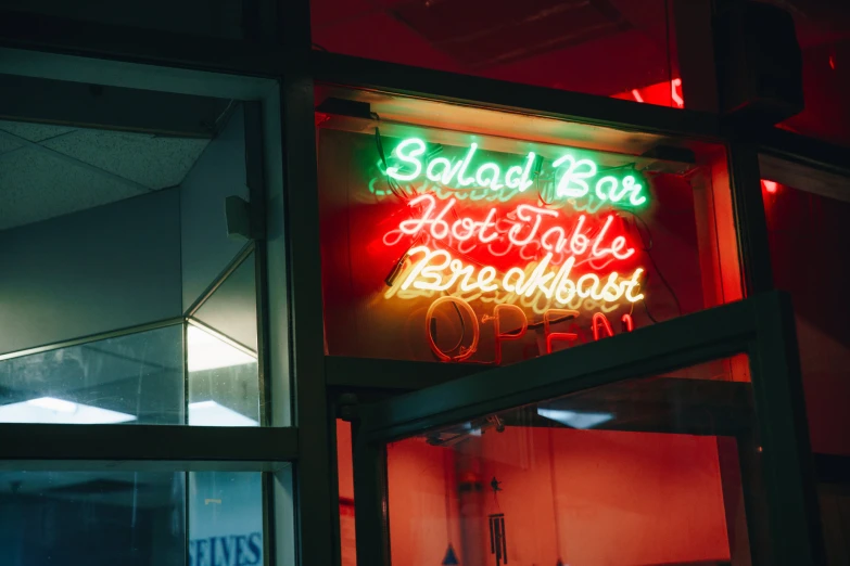 a neon sign in the window of a restaurant