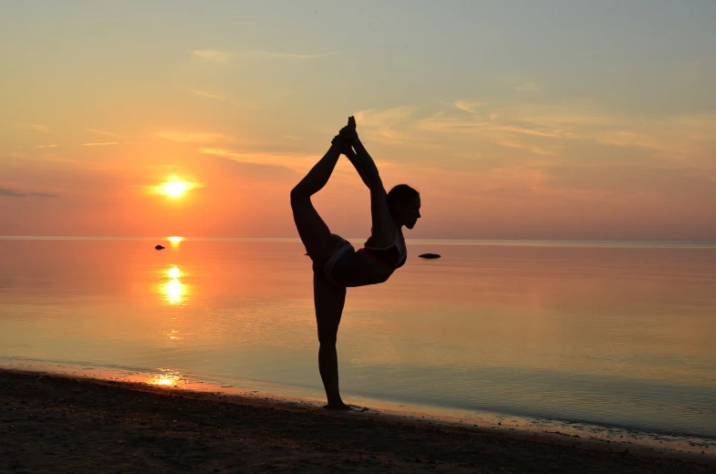 a woman standing on one leg in a yoga pose