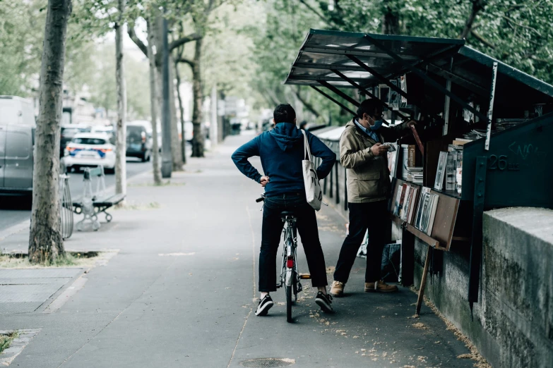 a man is on a bicycle next to a couple of people