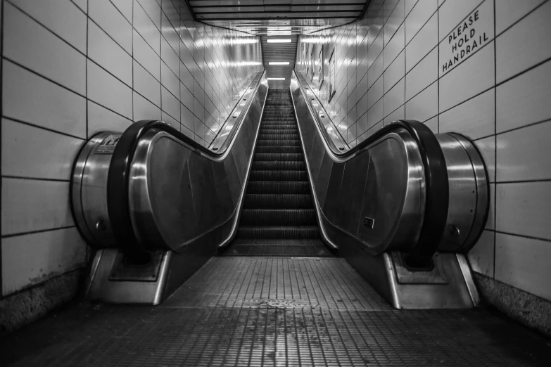 an empty escalator is pictured in this black and white po