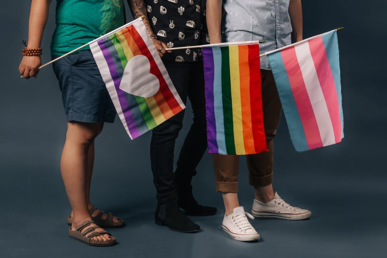 two girls and a boy holding colorful flags