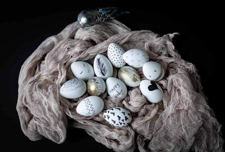 various colorful and white eggs are on a blanket