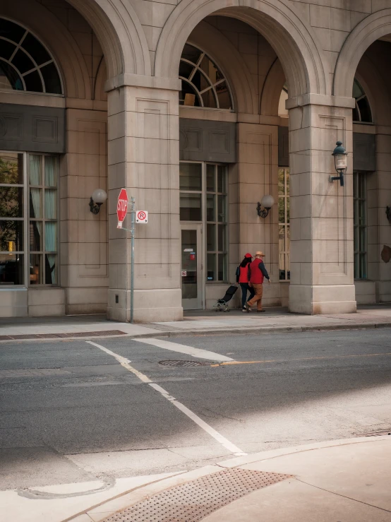 a man sitting at the corner of an intersection with his suitcase