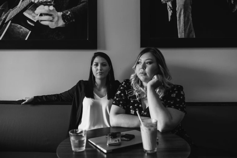 two women sitting at table in a restaurant looking off to the side