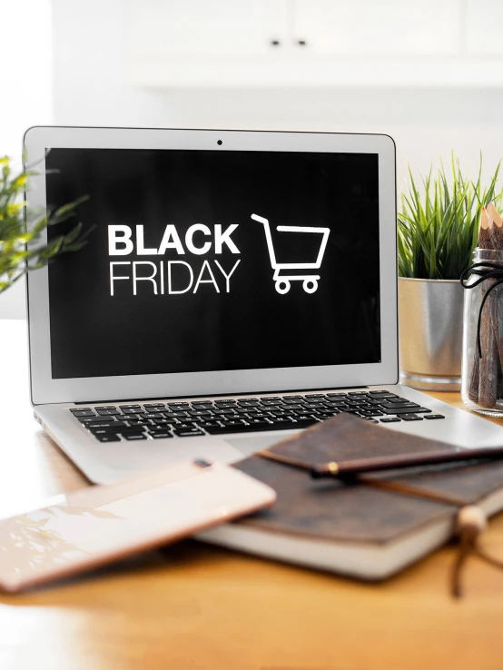 a black friday logo is displayed on the laptop