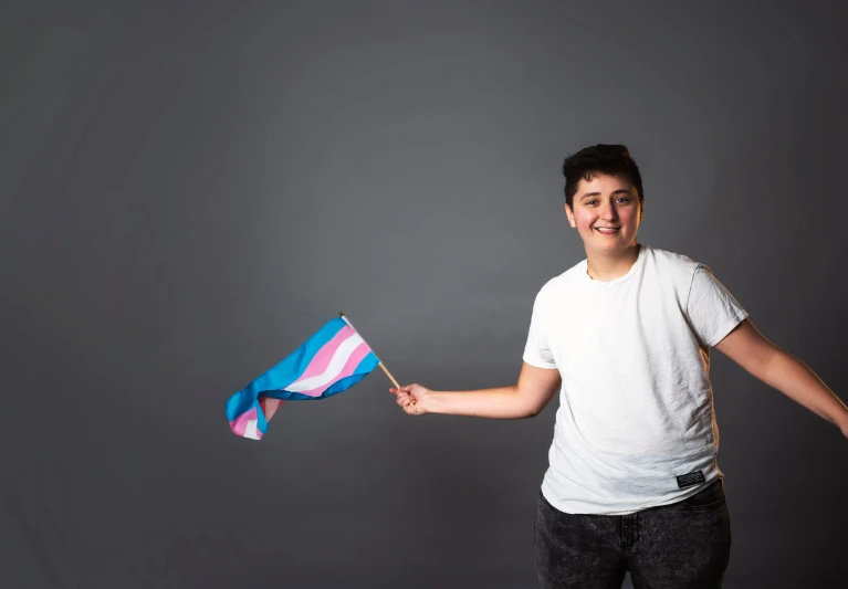 a boy is smiling and holding a blue flag
