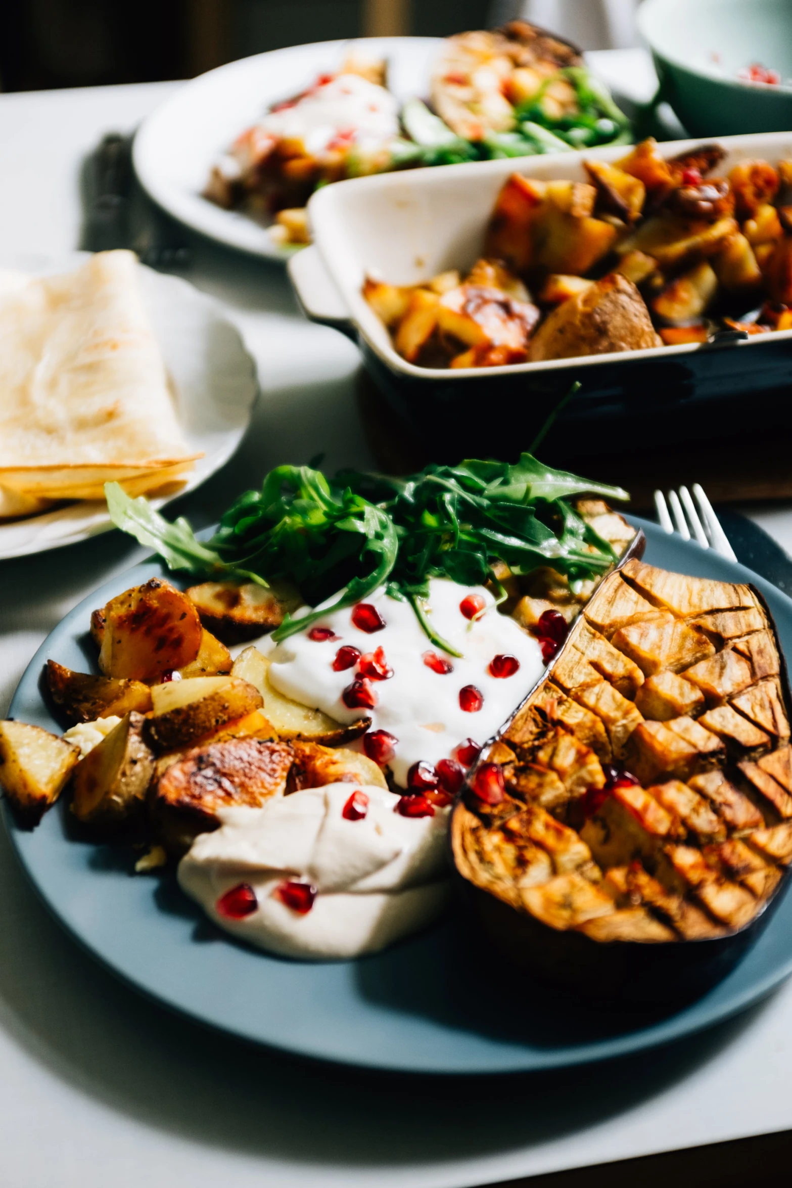 a plate of food sitting on a table near several plates of different foods