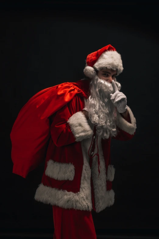 a man in a santa suit stands posing