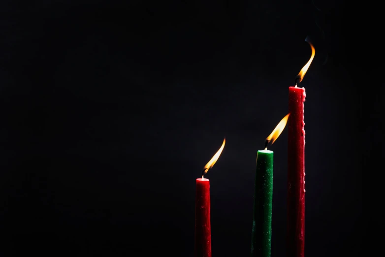 two candles with colorful candles lit on the side