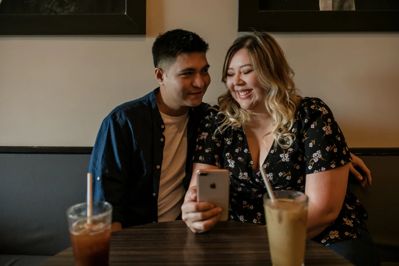 two people sitting at a table with drinks