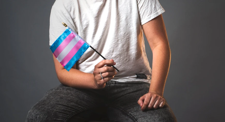 man with two flags on his back sitting on stool