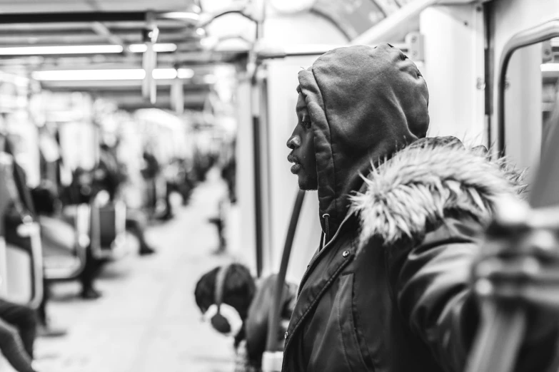 person wearing winter clothes in subway train and on subway