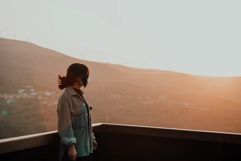 a young woman standing on top of a roof looking at the sky