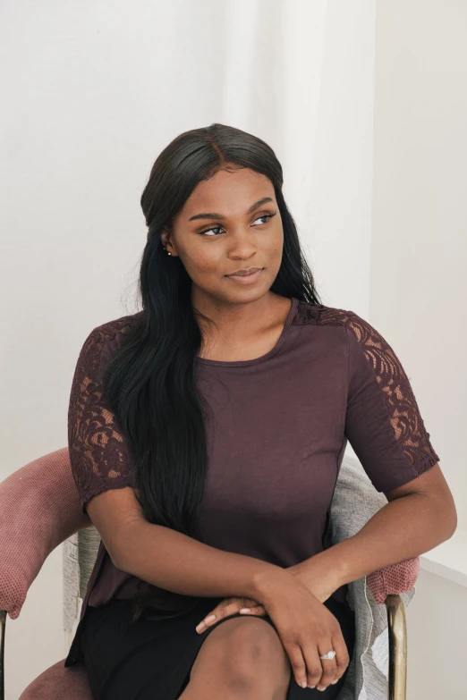 a black woman sitting in a chair, staring straight ahead