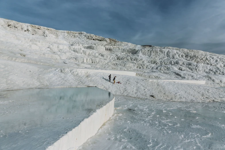 some people are walking along an ice covered field