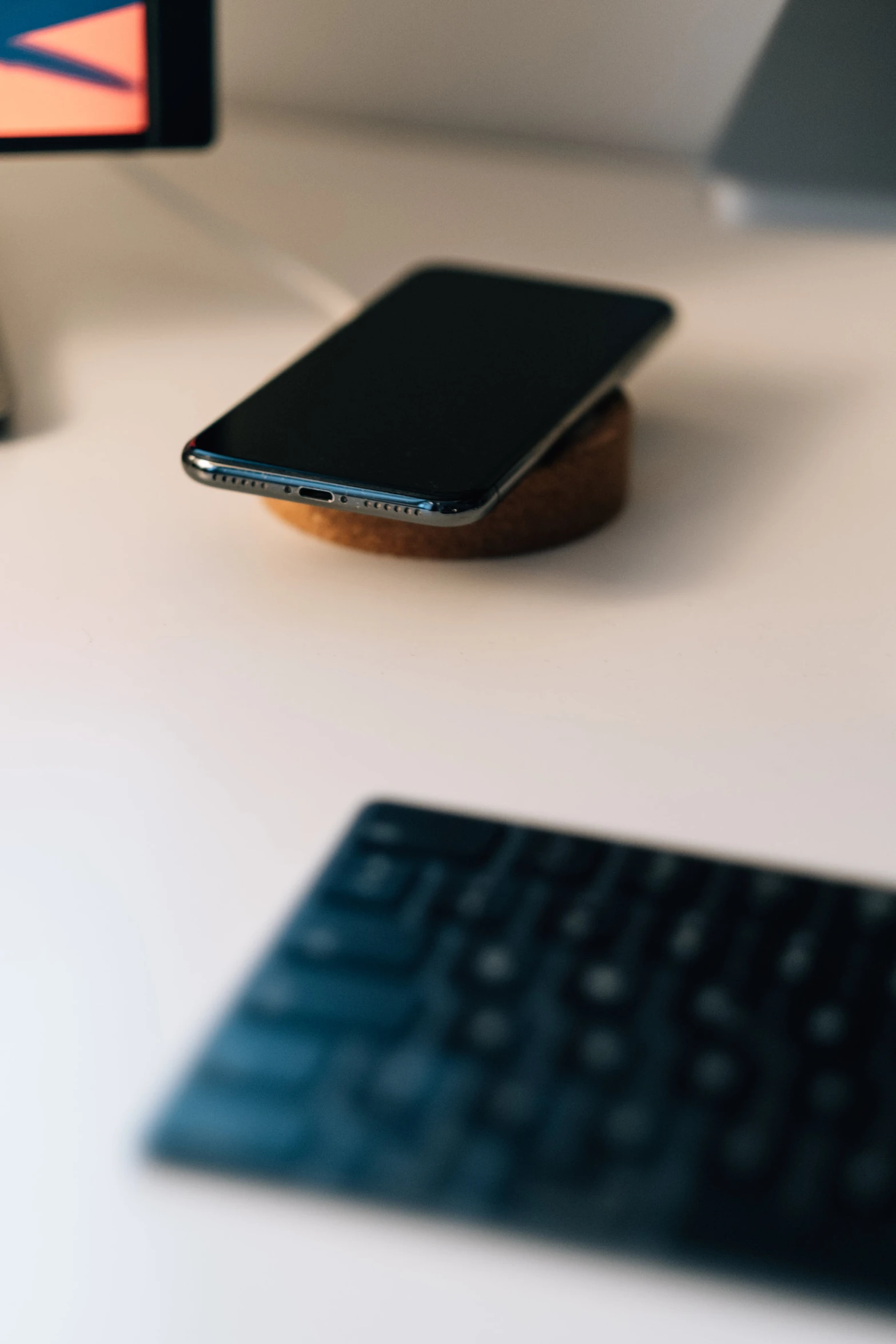 an apple iphone rests on the side of a keyboard