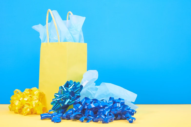 three bags of blue and gold ribbons next to each other