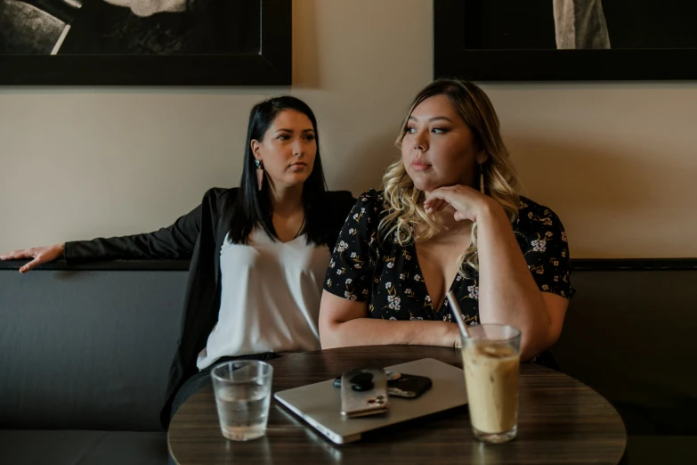 two women sit in a restaurant with drinks