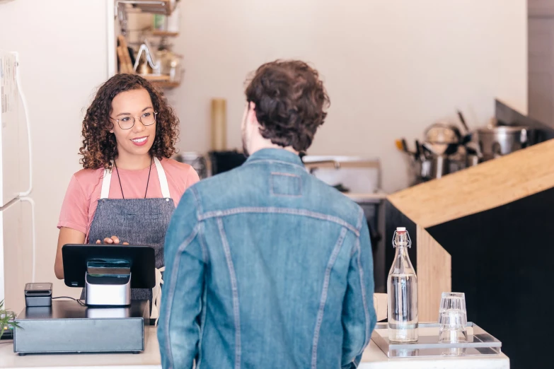 the waitress is standing at the counter and making the order