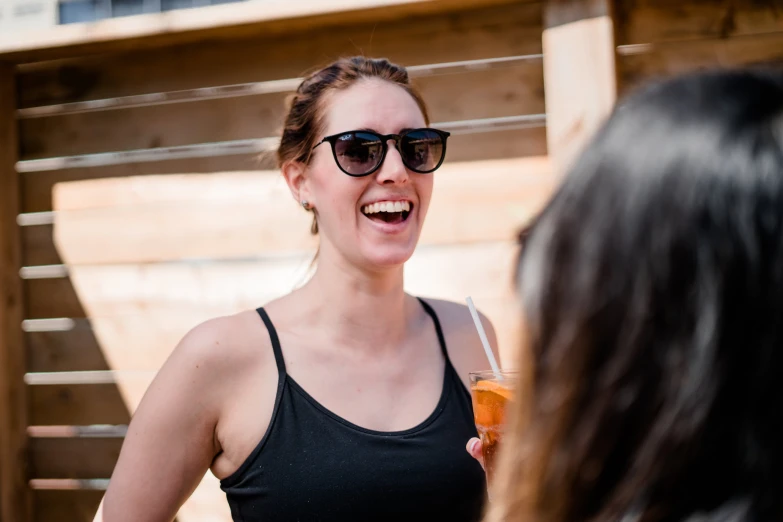 a woman with a soda cup standing by another woman