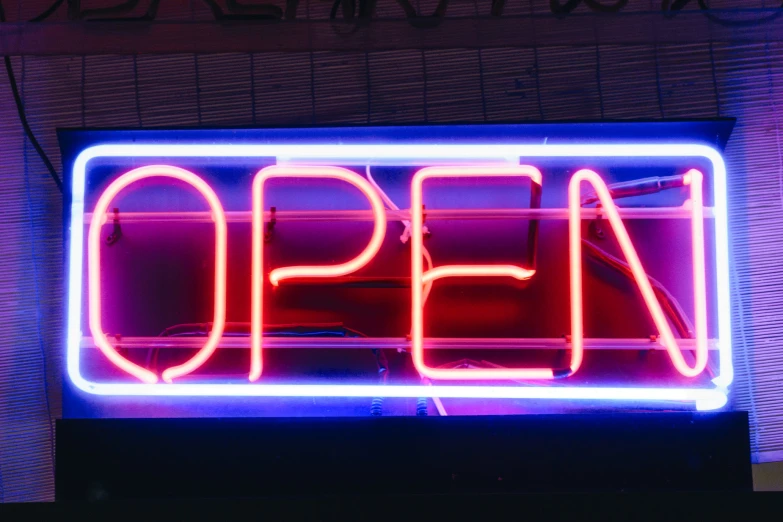 a neon sign advertising an open sign in the dark