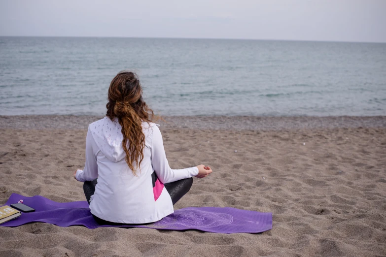 the woman is practicing yoga on the beach