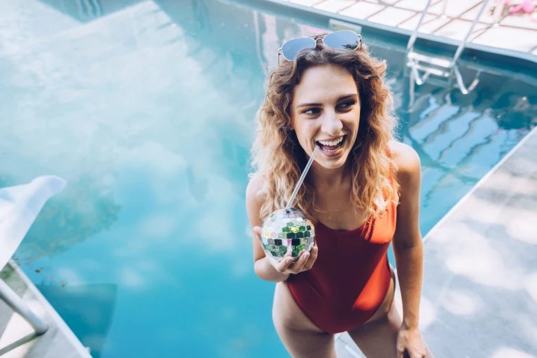 a woman in an orange swimsuit holding a drink