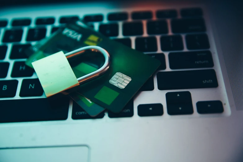 four credit cards sitting on a keyboard that has the keys to it