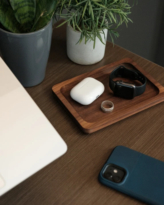 a white and blue phone sits on a tray beside an open laptop, phone and cellphone