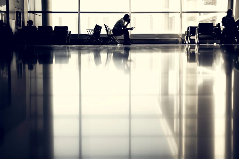 a person standing in an airport terminal waiting for their luggage