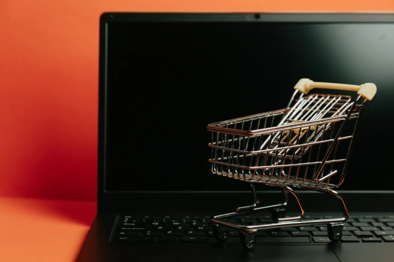 a small shopping cart sitting on top of a laptop keyboard