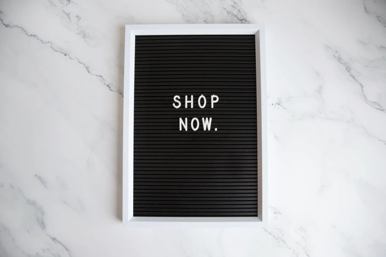 a white framed piece of paper with a shopping now written on it