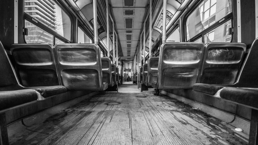 the interior of an empty subway car with a wooden floor