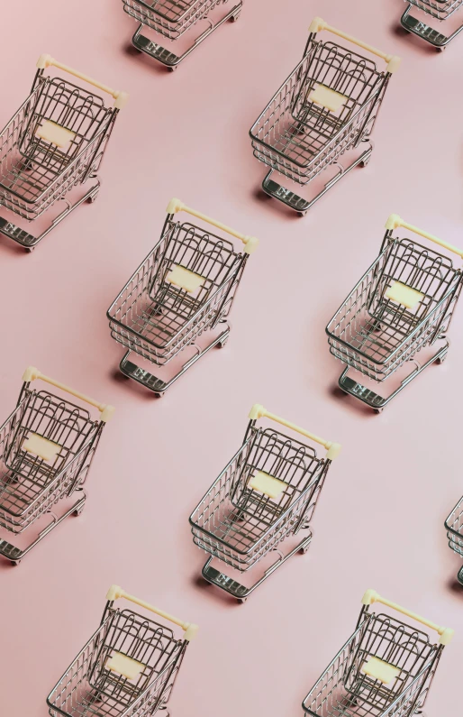 a pink wall with multiple metal shopping carts