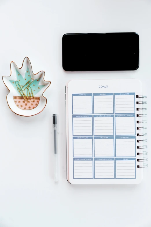 a table with a calendar, pen and phone on it