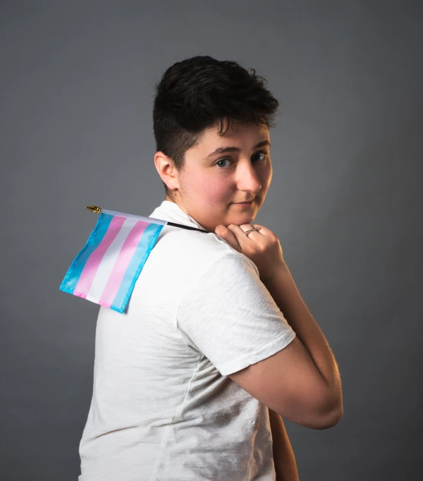a boy holding a striped bag over his shoulder