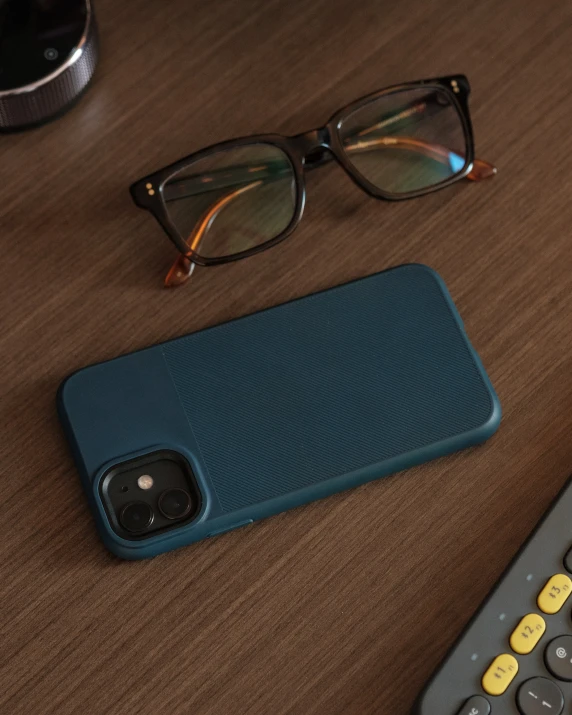 a phone, glasses and remote control on a table