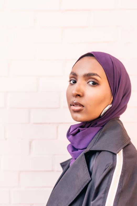 a woman wearing a purple scarf and a black jacket