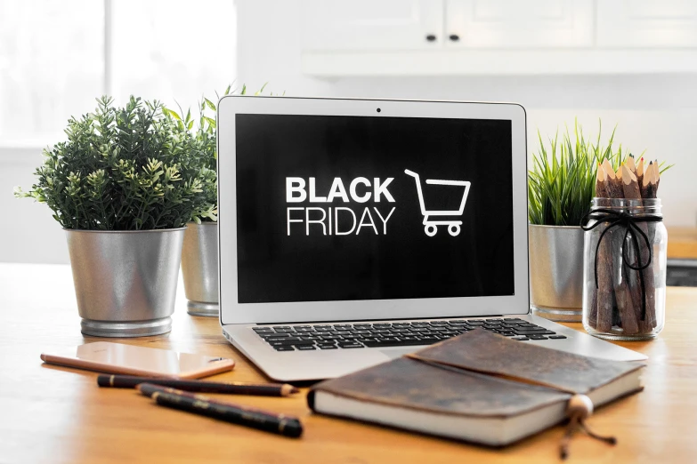 laptop with black friday on screen and leather accessories