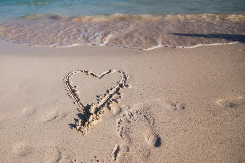 a heart shaped object in the sand at the beach